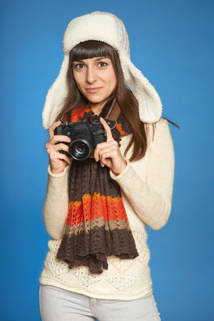 Woman photographer holding photo camera over blue の写真素材