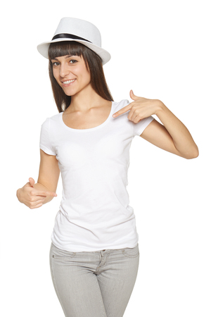 Smiling woman pointing at blank white t-shirtの写真素材