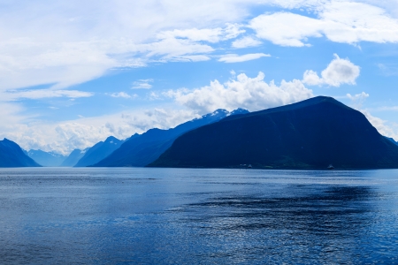 Mountains and fjord  blend in a blueish atmosphere in the late afternoon, Norwayの写真素材