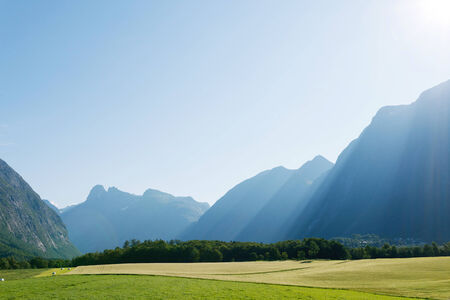 Sun rays in mountains lighting the valley, Norwayの写真素材