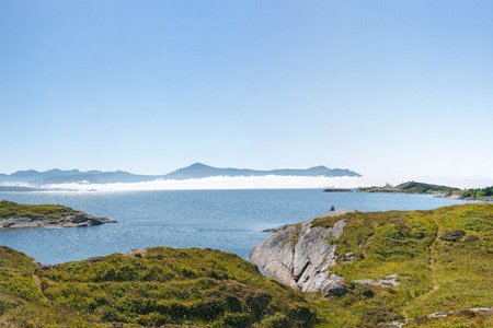view at Kvernesfjorden with clouds on the water and remote Atlantic Road. Man enjoying view.の写真素材