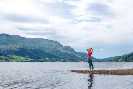 Enjoyment  - free happy woman enjoying landscape, Norway, in a summer cloudy day  Freedom, happiness and enjoyment concept の写真素材