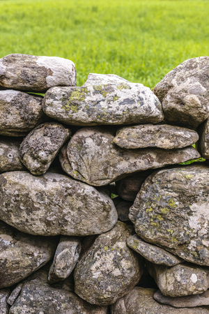 Fence made of rough stones covered by mossの写真素材