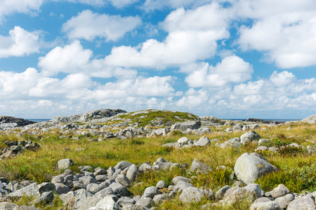 Wild stony landscape with blue sky and white clouds, Norwayの写真素材