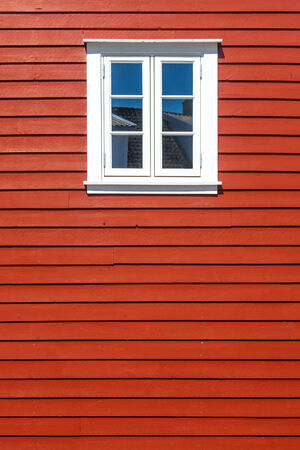 White wooden window on the traditional red wooden house wall, Norway, with copy spaceの写真素材