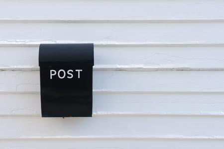 Black mail box on the traditional white wooden wall of house, Norwayの写真素材