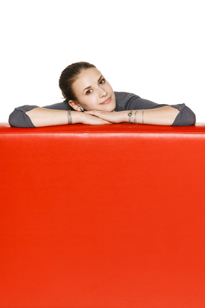 Calm relaxed woman leaning on the red leather couchの写真素材