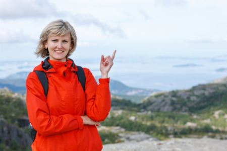 Happy woman outdoors pointing up at copy spaceの写真素材