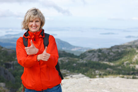 Happy woman gesturing thumbs up outdoorsの写真素材