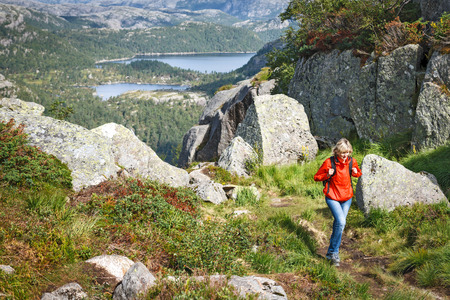 Woman with backpack hiking on wild nature of Norwayの写真素材