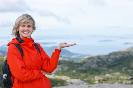 Happy woman tourist showing / holding blank copy space on the palm outdoorsの写真素材