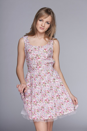 Beautiful woman in feminine floral sundress over grayの写真素材