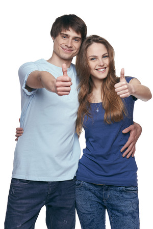 Happy couple with thumbs up sign isolated on white の写真素材