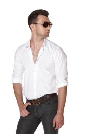 Young fashion male in white shirt and sunglasses posing looking away, over white の写真素材