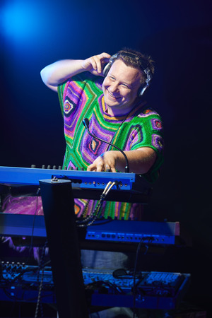 Happy mid age musician playing on a keyboard at a concertの写真素材