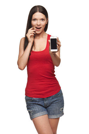Excited surprised woman showing cell phone with black screen over white backgroundの写真素材