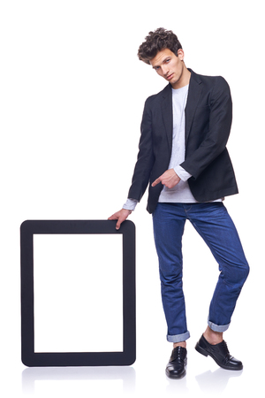 Full length man with empty frame - copy space for text pointing at it, over white backgroundの写真素材