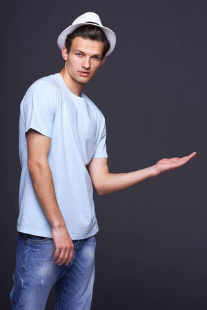 Stylish man fashion model showing open hand palm with copy space for product or textの写真素材
