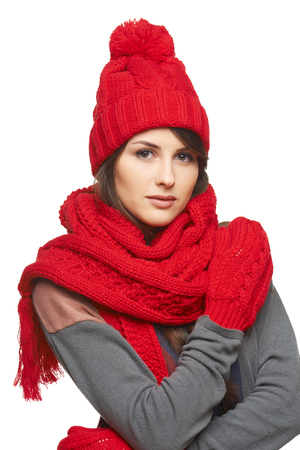 Winter, christmas, holidays concept. Beautiful woman in red hat, scarf and mittens over gray backgroundの写真素材