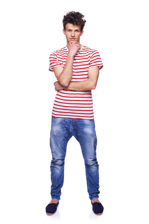 Full length casual trendy man with modern haircut posing in jeans and striped tshirt, over white の写真素材