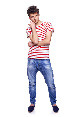 Full length casual trendy man with modern haircut posing in jeans and striped tshirt, over white backgroundの写真素材
