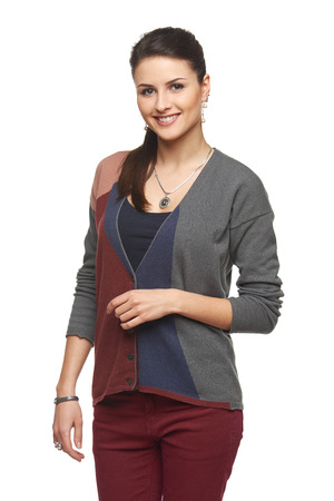 Portrait of lovely smiling young girl in cardigan looking at camera, over white backgroundの写真素材