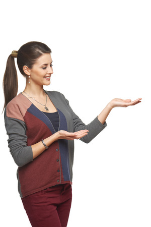 Smiling woman in autumn cardigan showing open hand palm with copy space for product or textの写真素材