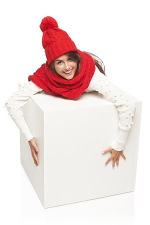 laughing winter woman wearing knitted warm red scarf and hat hugging big white boxの写真素材