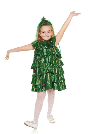 Funny 7 years old girl in Christmas tree costume feeling happy with hands outspread, over white backgroundの写真素材