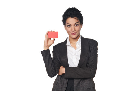Smiling african american business woman showing blank credit card, over white backgroundの写真素材