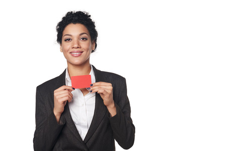 Smiling african american business woman showing blank credit card, over white の写真素材