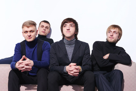 Young men sitting on a sofa indoorsの写真素材