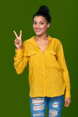 Happy mixed race african american - caucasian woman showing one finger, directing upの写真素材