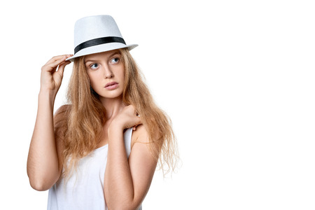 Closeup of beautiful slytish woman posing in fedora hat looking away at blank copy space, over white backgroundの写真素材