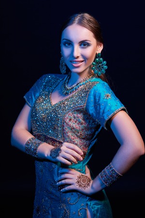 Fine art portrait of beautiful fashion Indian woman with oriental dress, accessories- earrings,...