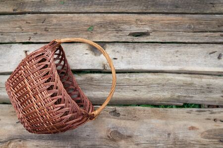 Empty wicker basket on weathered wooden backgroundの写真素材