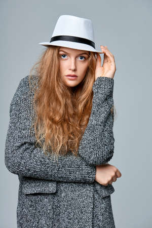 Fashionable beautiful woman in warm knitted cardigan, over gray backgroundの写真素材