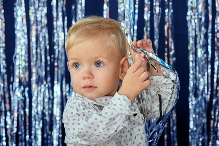 Adorable toddler child playing with Xmas decoration garland
