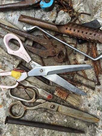 Old rusted tools over concrete, top view