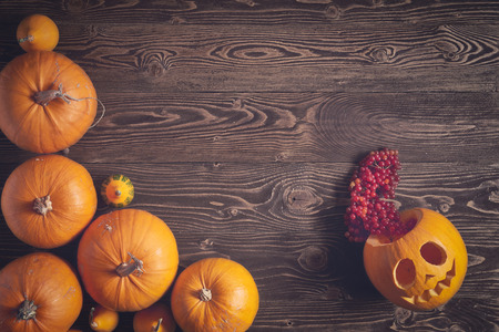 Halloween pumpkins over wooden background, top view, flat lay with copy space for text, toned imageの写真素材