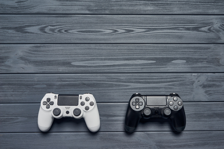 Computer game competition. Gaming concept. Top view of two joysticks on wooden table