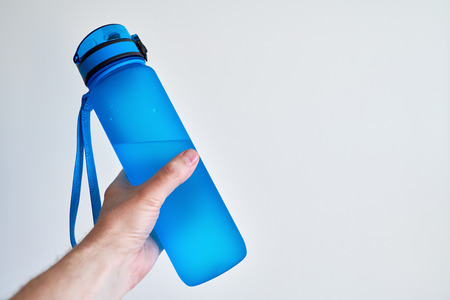 Hand holding blue water bottleの写真素材