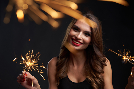 Party, drinks, holidays and celebration concept. Woman with dancing with sparklers in handsの写真素材