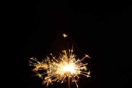 A burning sparkler on a black backgroundの写真素材