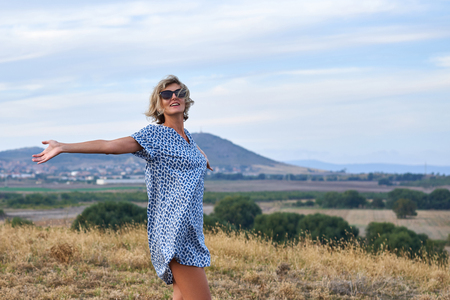 Happy woman enjoying with arms spreaded outdoorsの写真素材