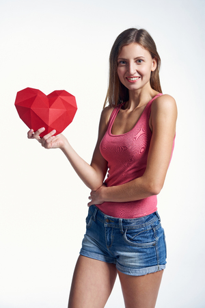 Young woman in denim shorts showing holding on the palm blank copy space over white backgroundの写真素材