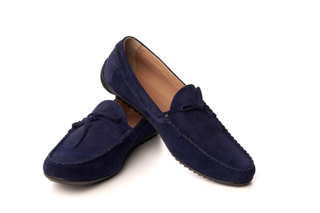 Dark blue suede man's moccasins shoes. Studio shot over white backgroundの写真素材