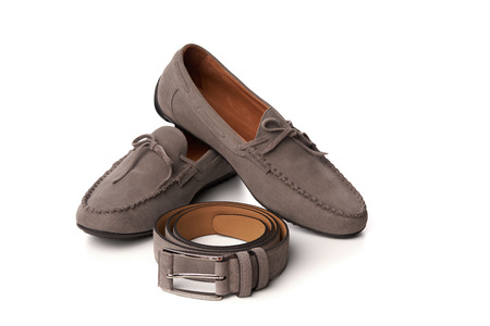 Beige suede men's moccasins shoes with a belt. Studio shot over white backgroundの写真素材