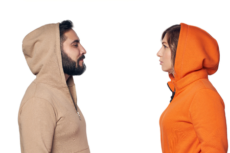 Young couple in casual clothes standing face to face looking at each other with intenseの写真素材