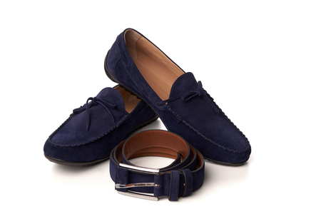 Dark blue suede man's moccasins shoes with a belt. Studio shot over white backgroundの写真素材